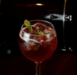 a-glass-filled-with-a-drink-sitting-on-top-of-a-wooden-table.jpg a glass filled with a drink sitting on top of a wooden table